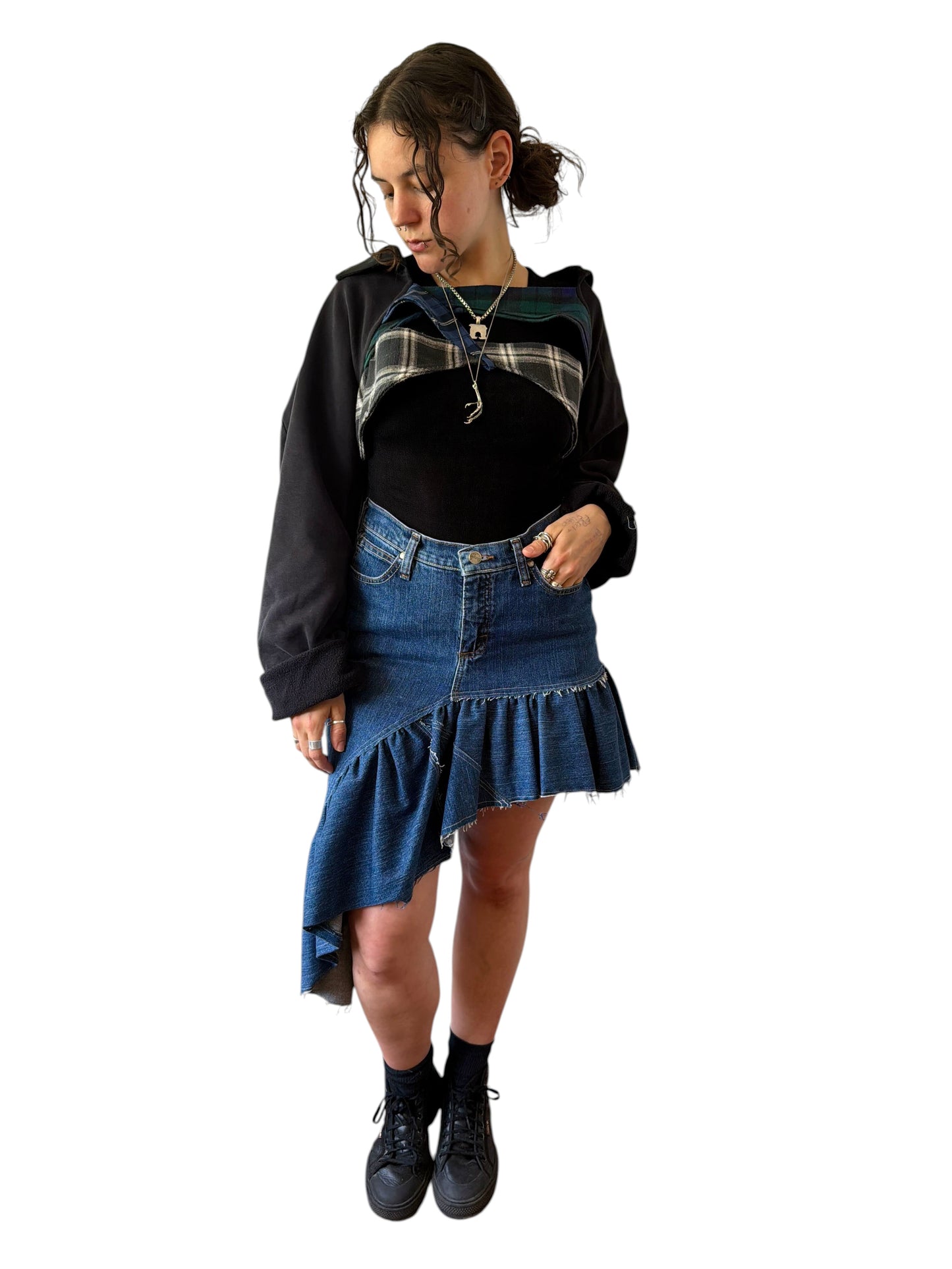 0 mph shrugly made from upcycled black pants and green plaid flannel scraps, worn by a model over a black top.