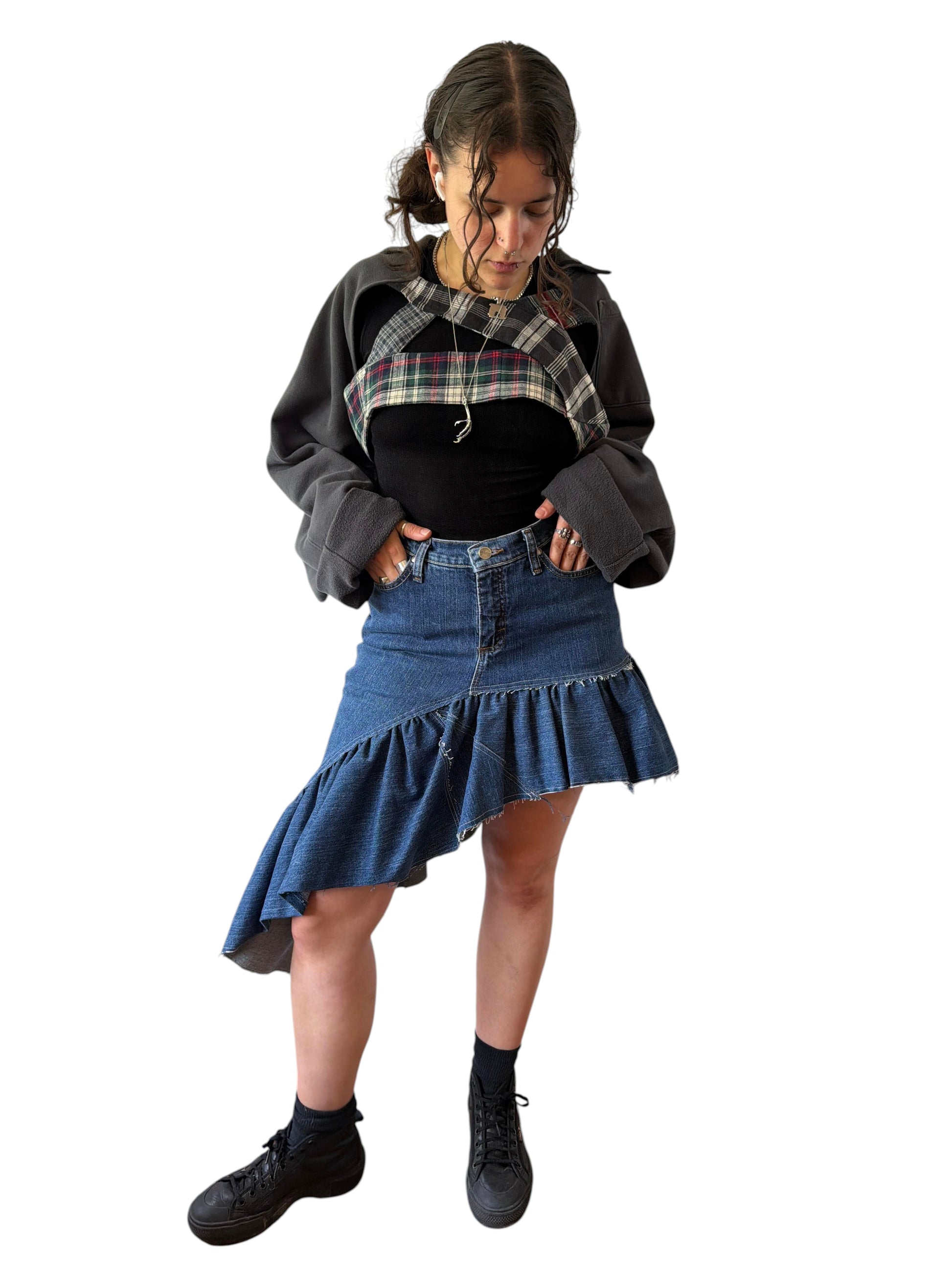 0 mph upcycled shrug made from flannel and pants scraps, worn by a model over a black top and denim skirt.