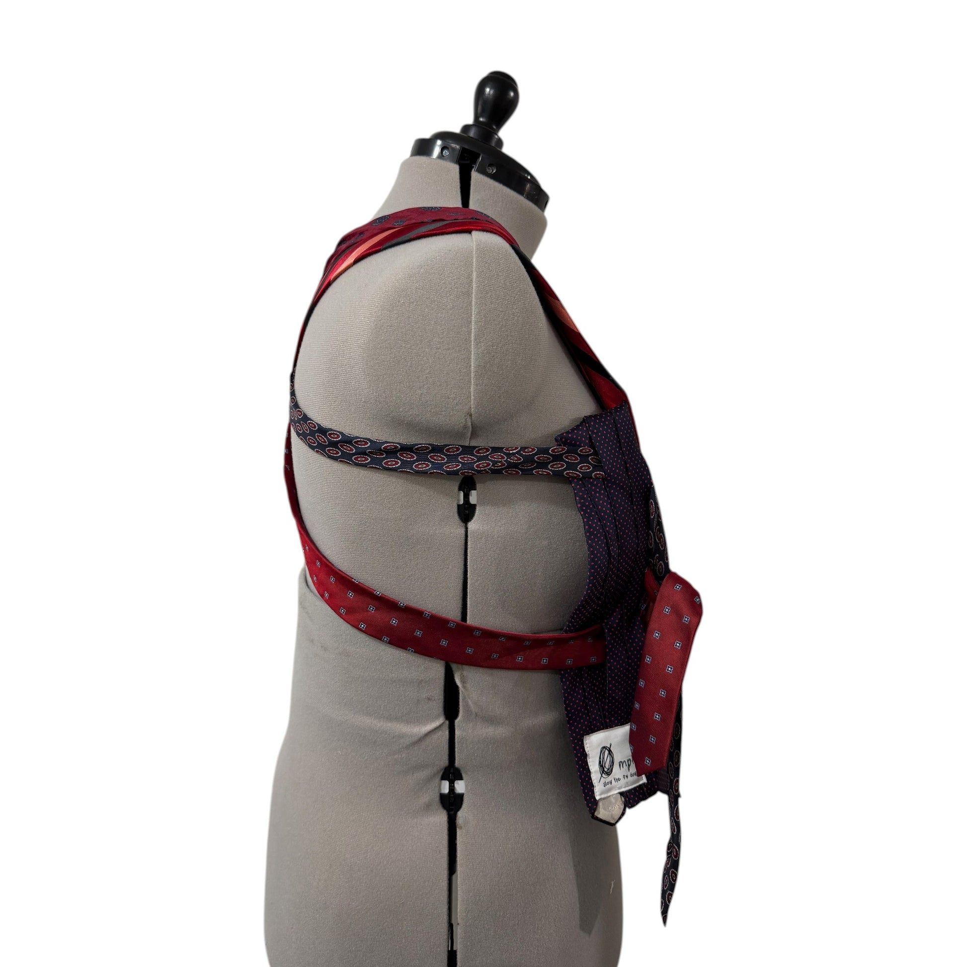 0 mph upcycled necktie corset top in red and navy blue patchwork silk on a dress form, side view.