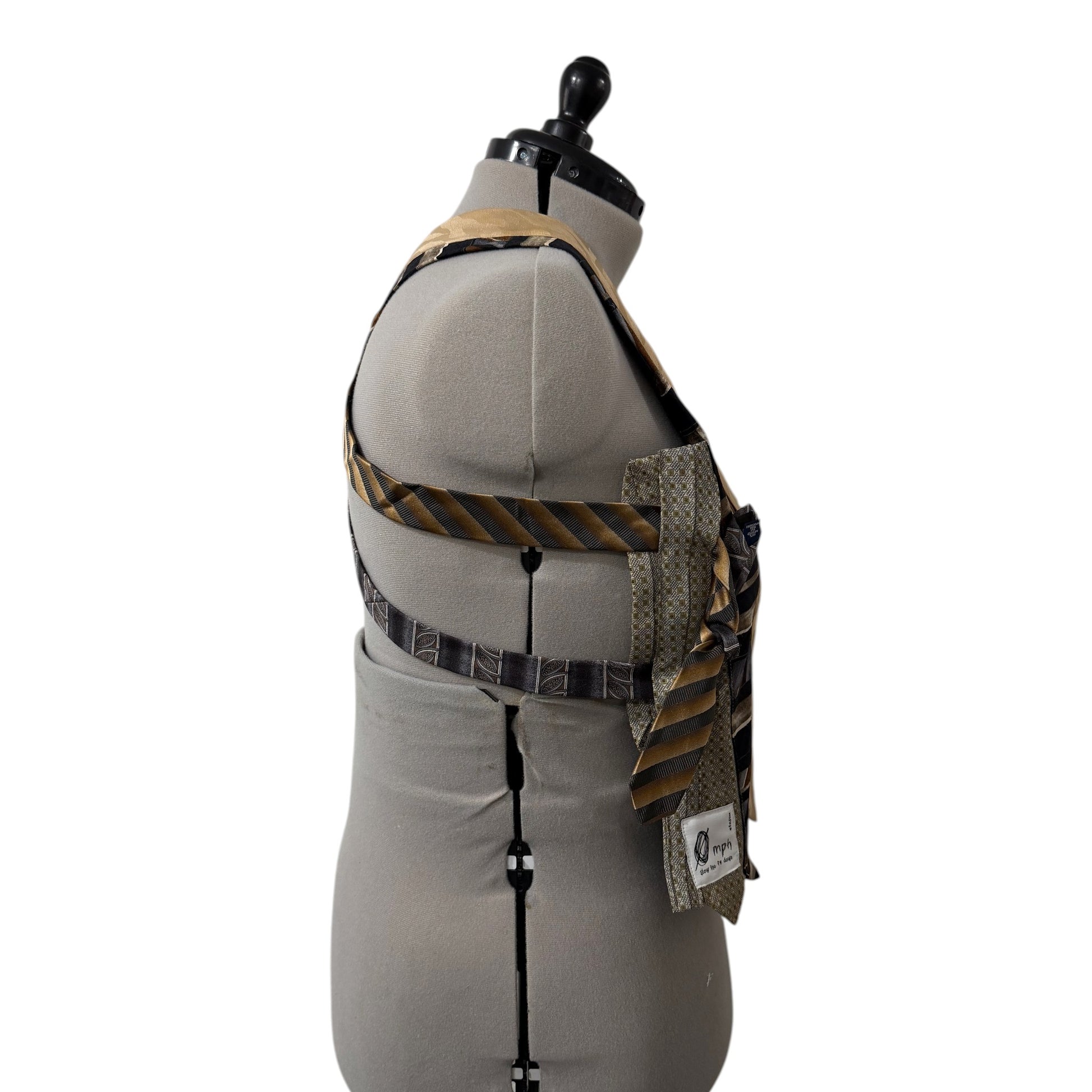 0 mph upcycled patchwork vest made from brown, gold, and black silk neckties on a mannequin, side view.
