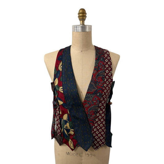 0 mph upcycled necktie vest featuring patchwork silk patterns in red, blue, and geometric motifs on a mannequin.